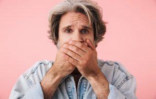 Man covering mouth (Bad Breath What Causes it and What to Do About it)