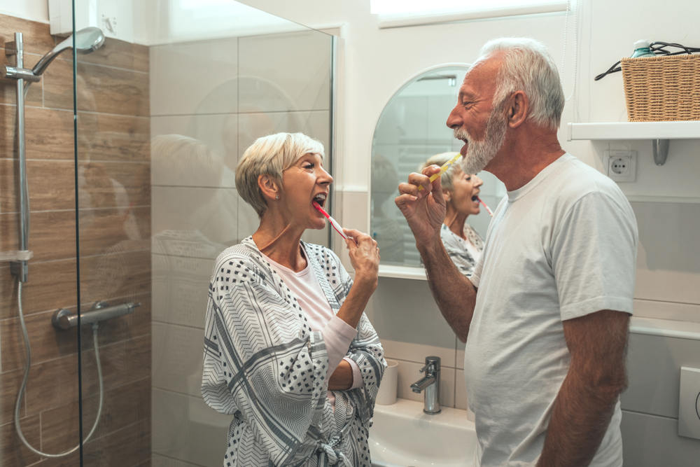 Seniors brushing teeth to ensure dental health for dental implants