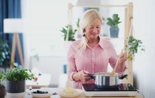 Senior Woman Cooking - Debunking 4 Common Myths About Oral Health and Seniors